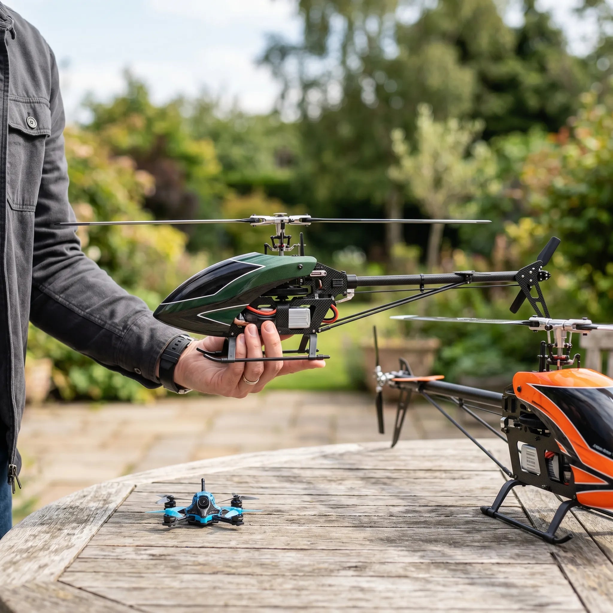 Person holding a remote control helicopter on a wooden surface with trees in the background