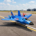 Blue RC F-22 airplane on a runway with a clear sky background