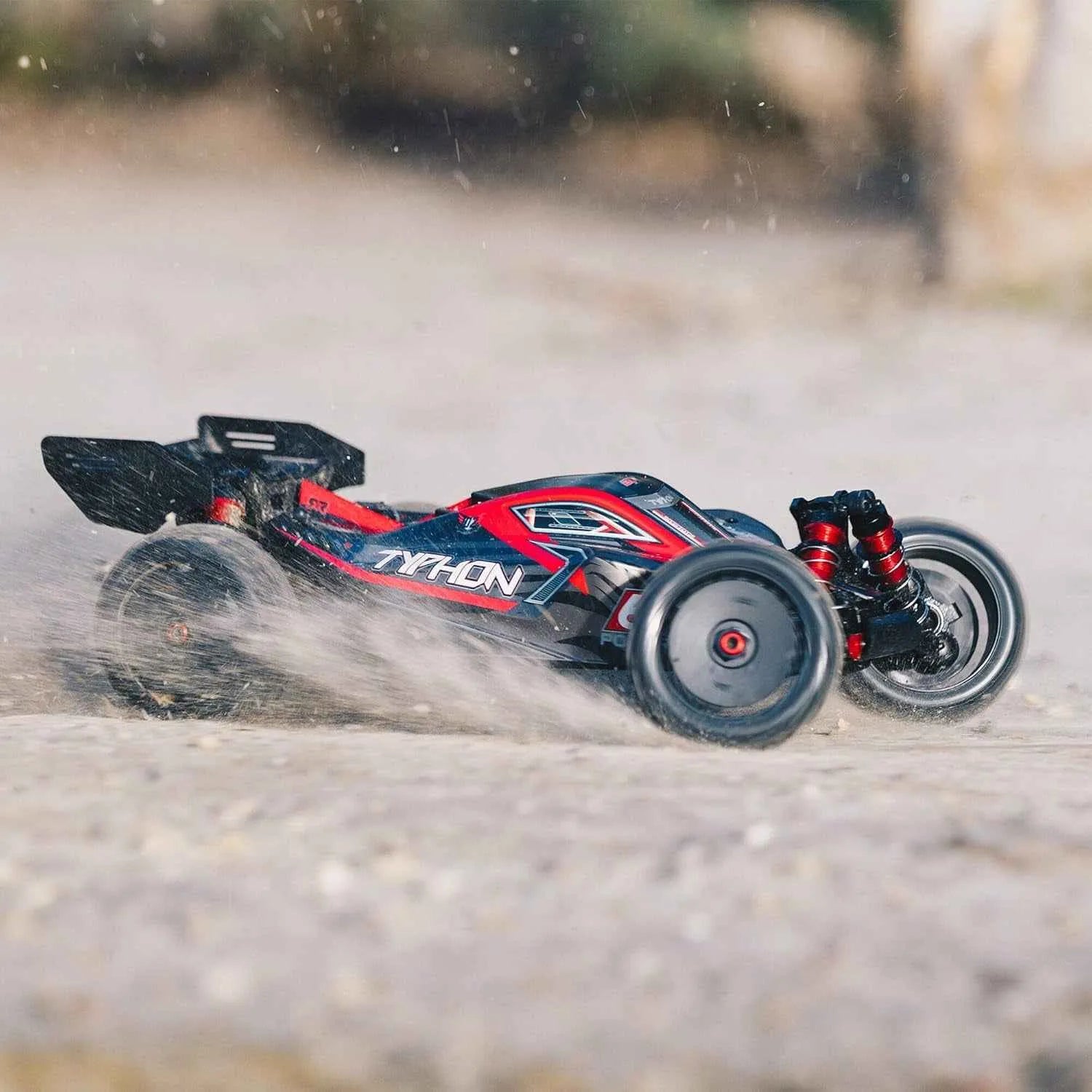 Red and black remote control buggy on a dirt track