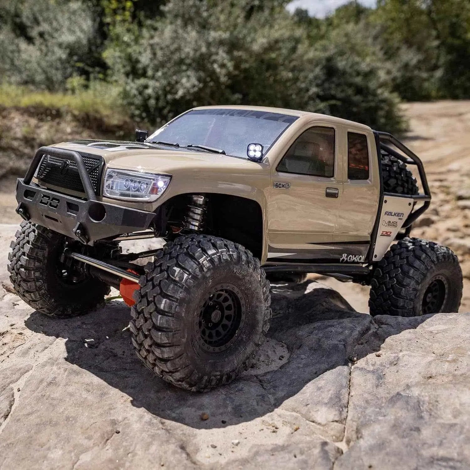 Beige off-road crawler with large tires on a rocky terrain
