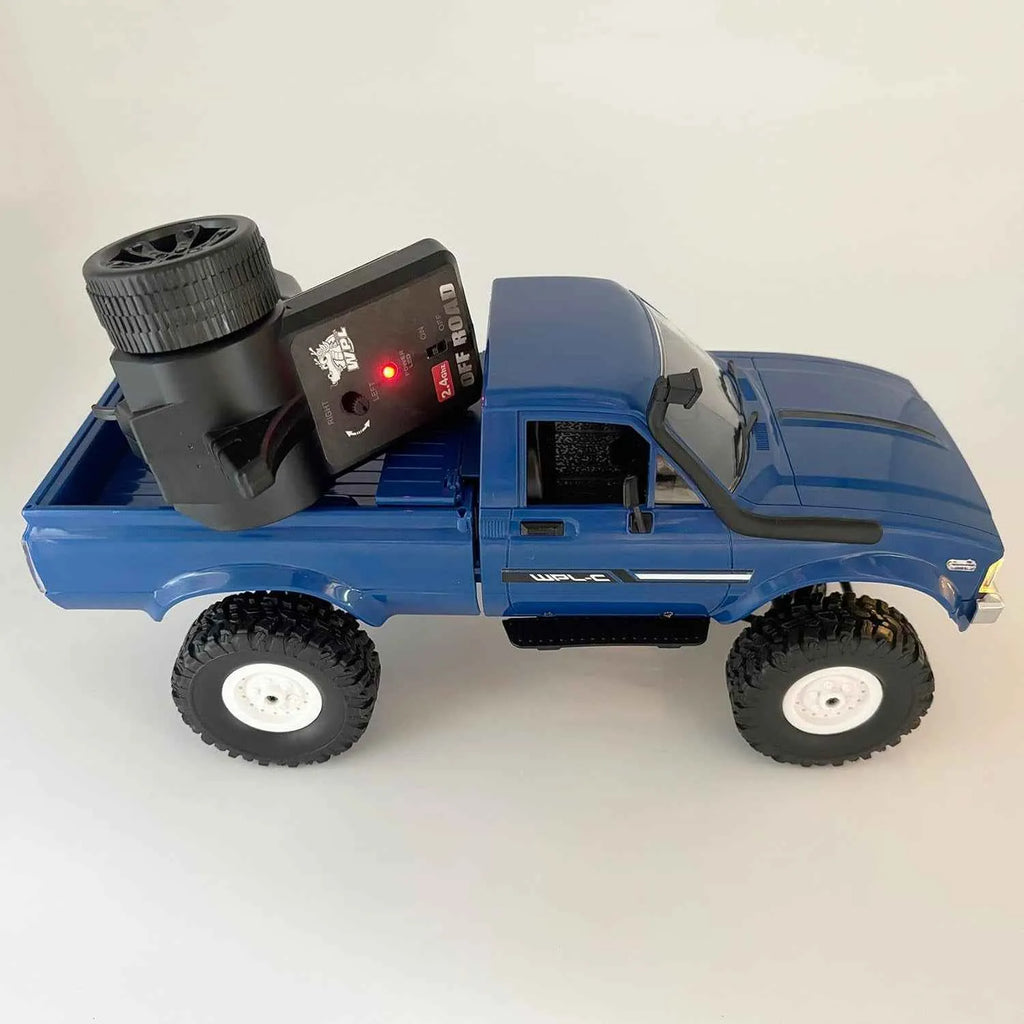 Blue RC crawler with remote control on a white background