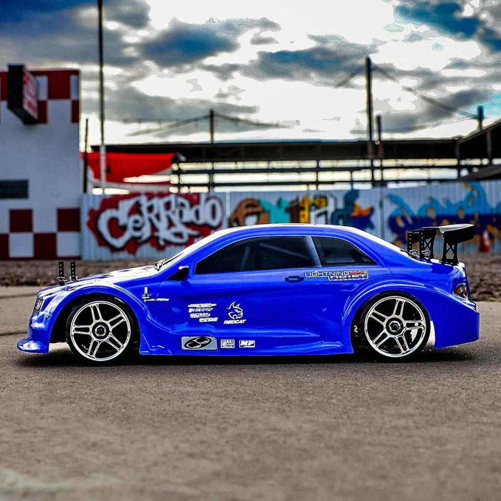 Blue rc drift car on a track with graffiti-covered wall in the background