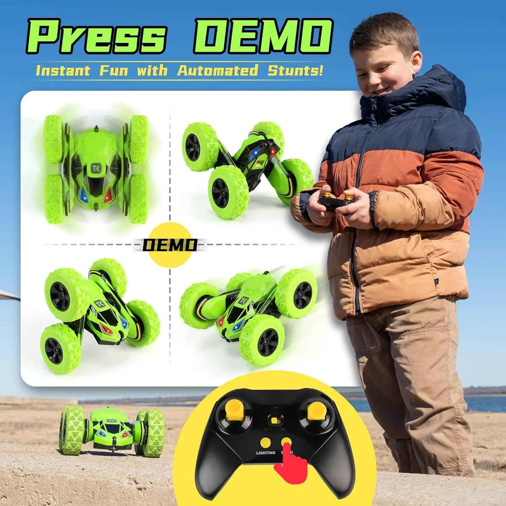 Child playing with a remote control stunt car on a beach