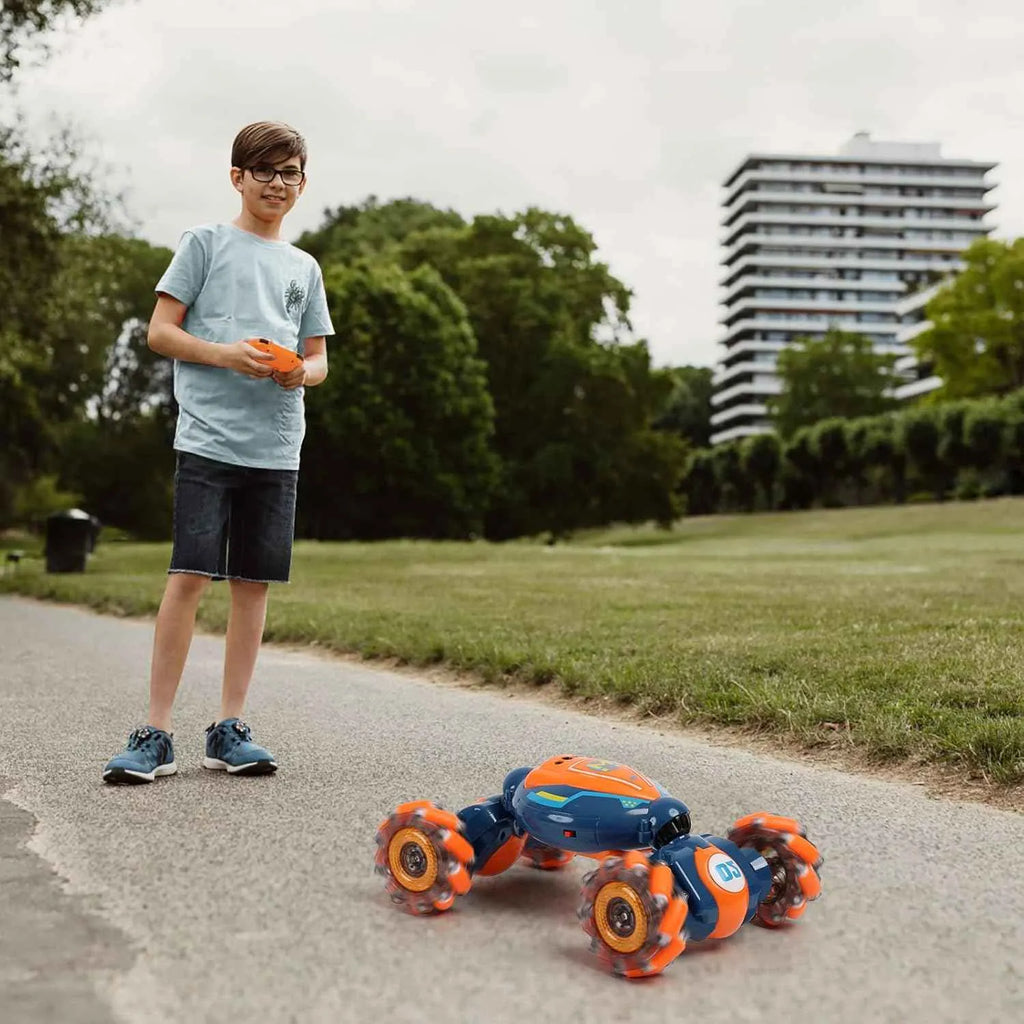 Child playing with remote control stunt car on a path in a park