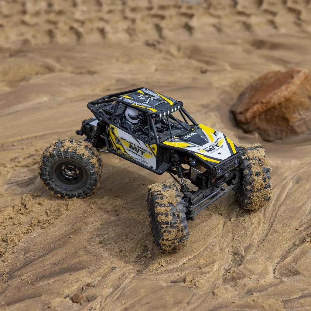Model off-road crawler on sandy terrain with desert landscape