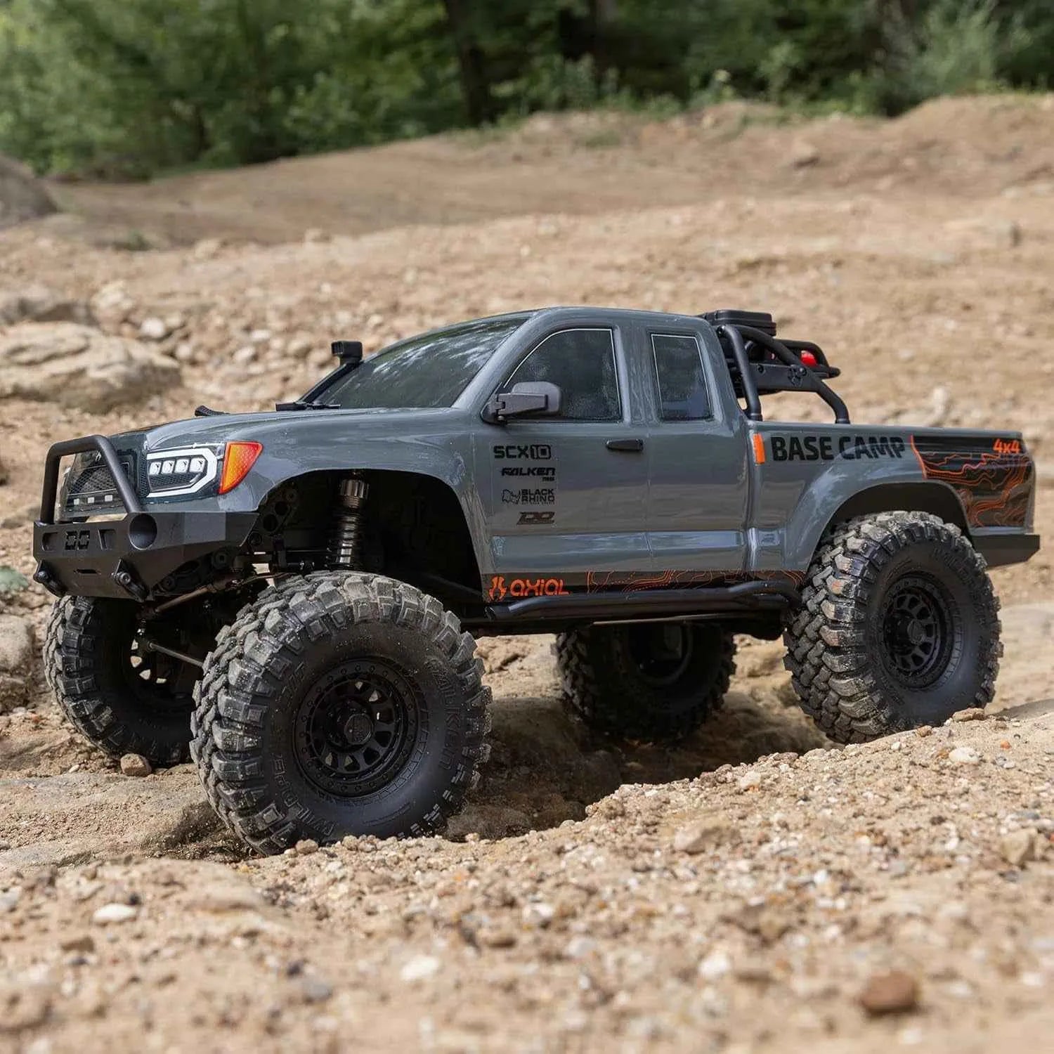 Gray off-road RC crawler with large tires on a dirt terrain