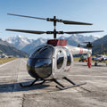 Gray RC Helicopter on a runway with mountains in the background