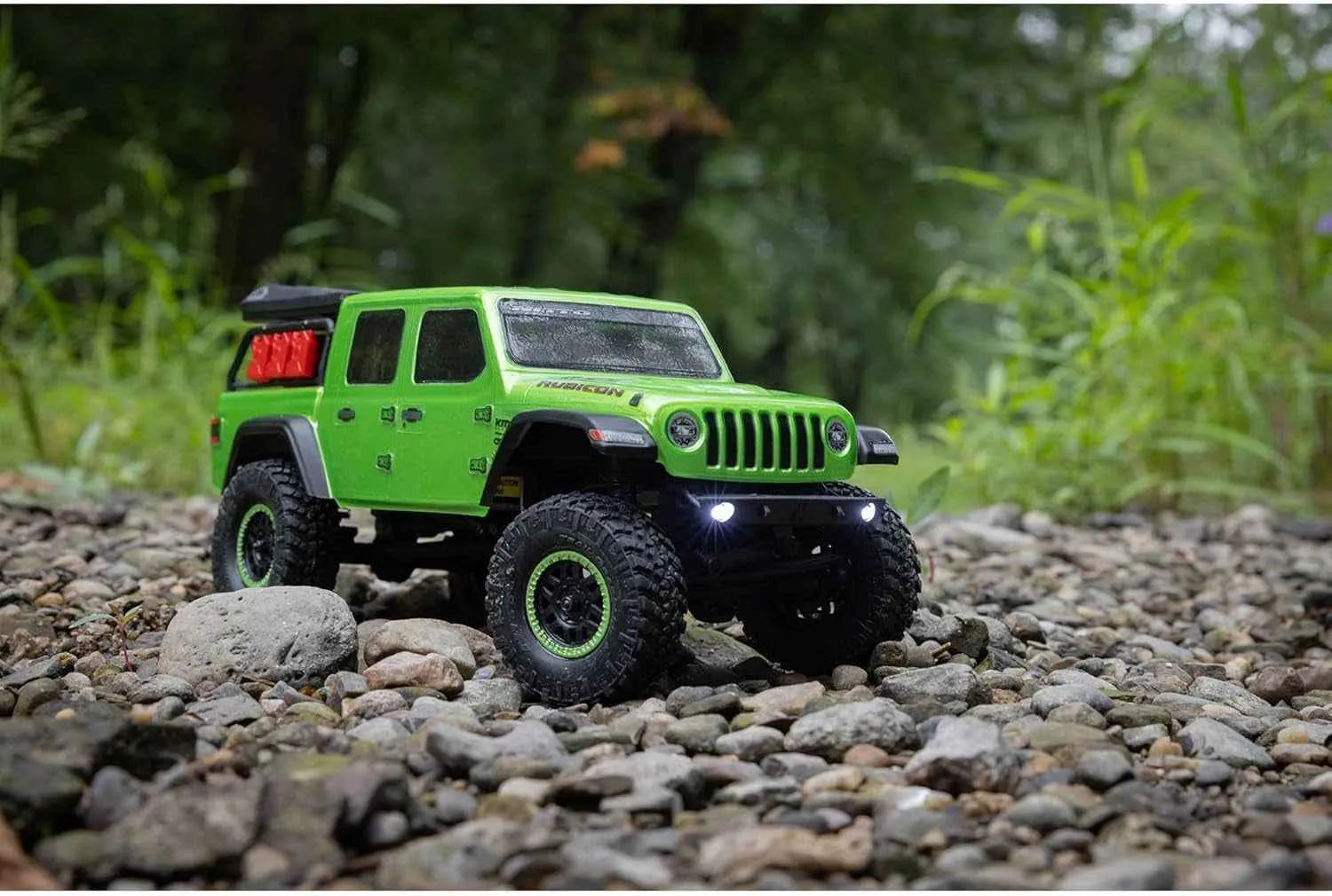 Green RC crawler on a rocky surface with a natural background
