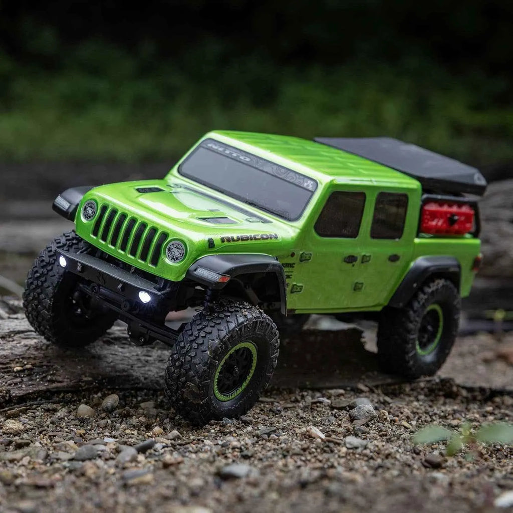 Green RC crawler Rubicon on a rocky surface with a blurred natural background
