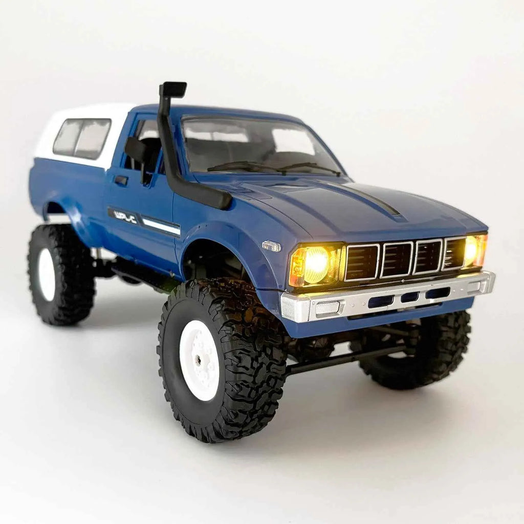 Model of a blue RC crawler with large wheels on a white background
