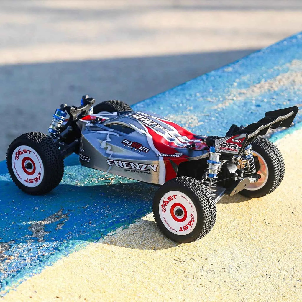 Model of a remote control buggy on a sandy surface with water in the background