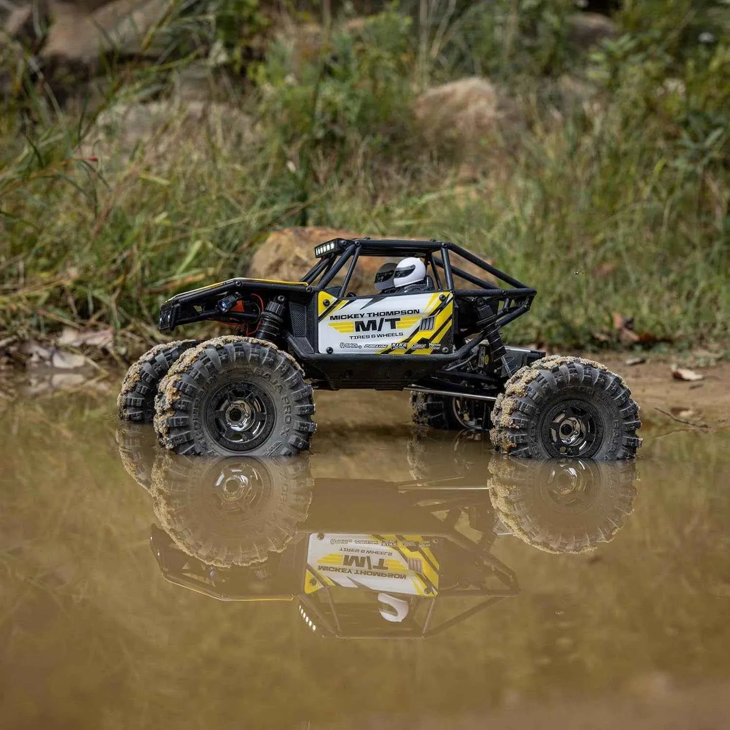 Model off-road crawler on a grassy and water-covered terrain