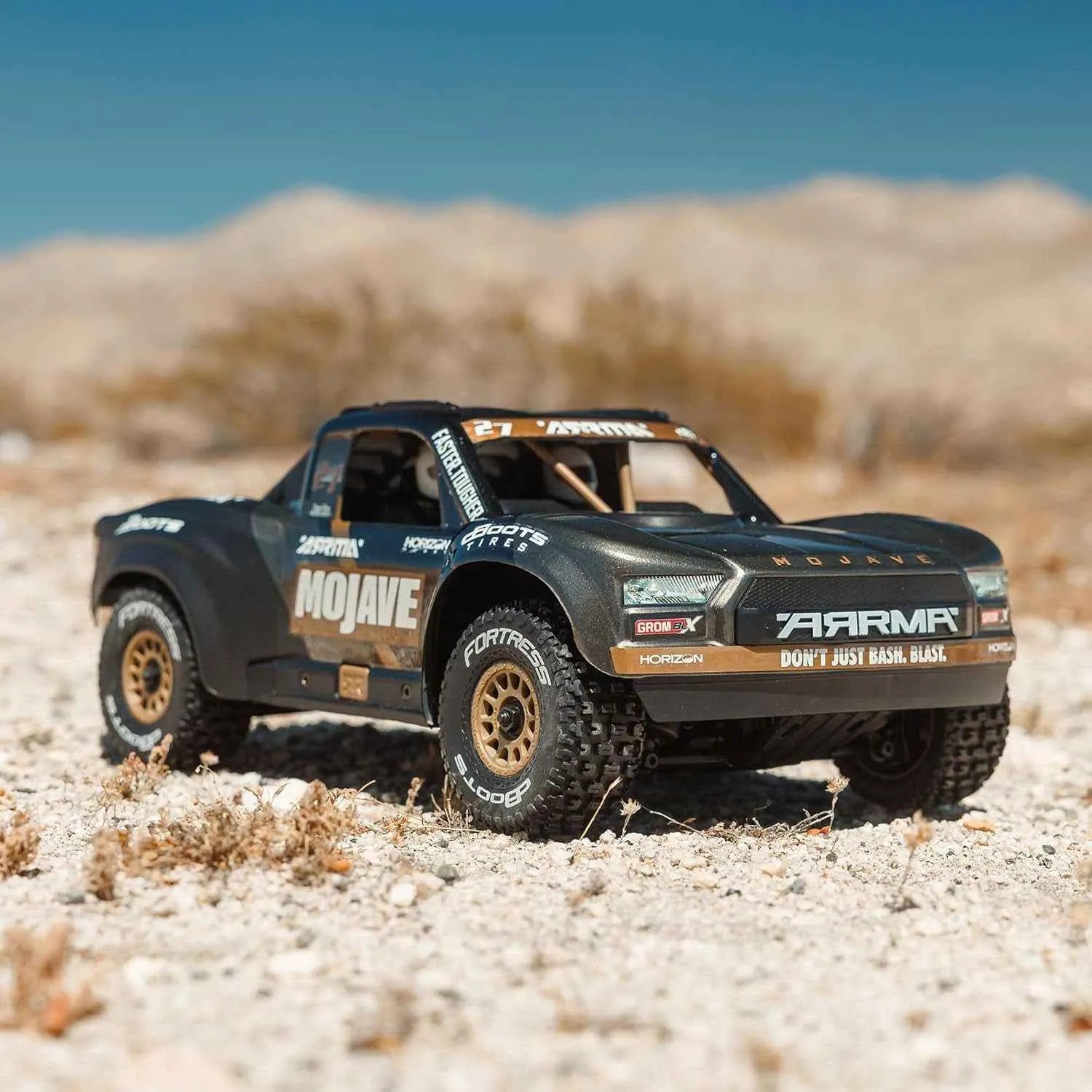 Model off-road truck in a desert setting with 'ARRMA' branding.