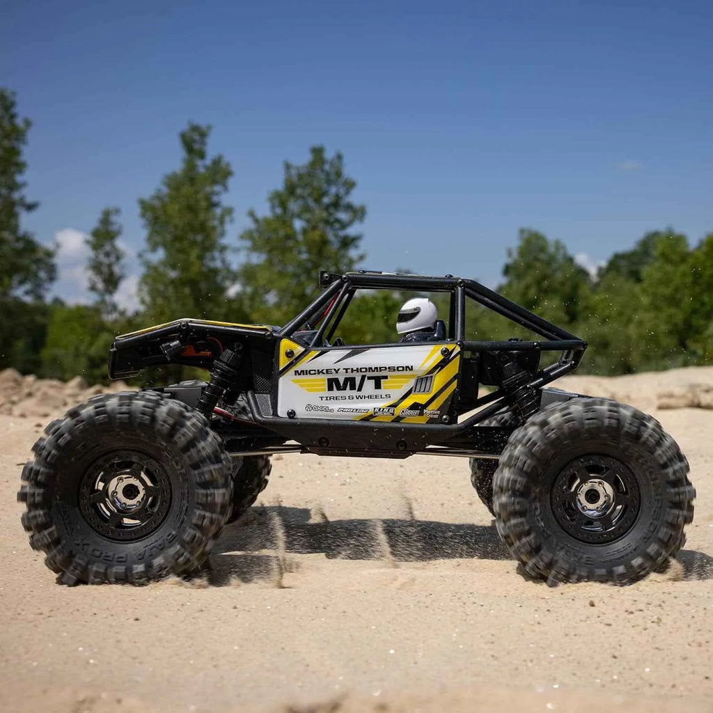 Off-road crawler on a sandy terrain with trees in the background