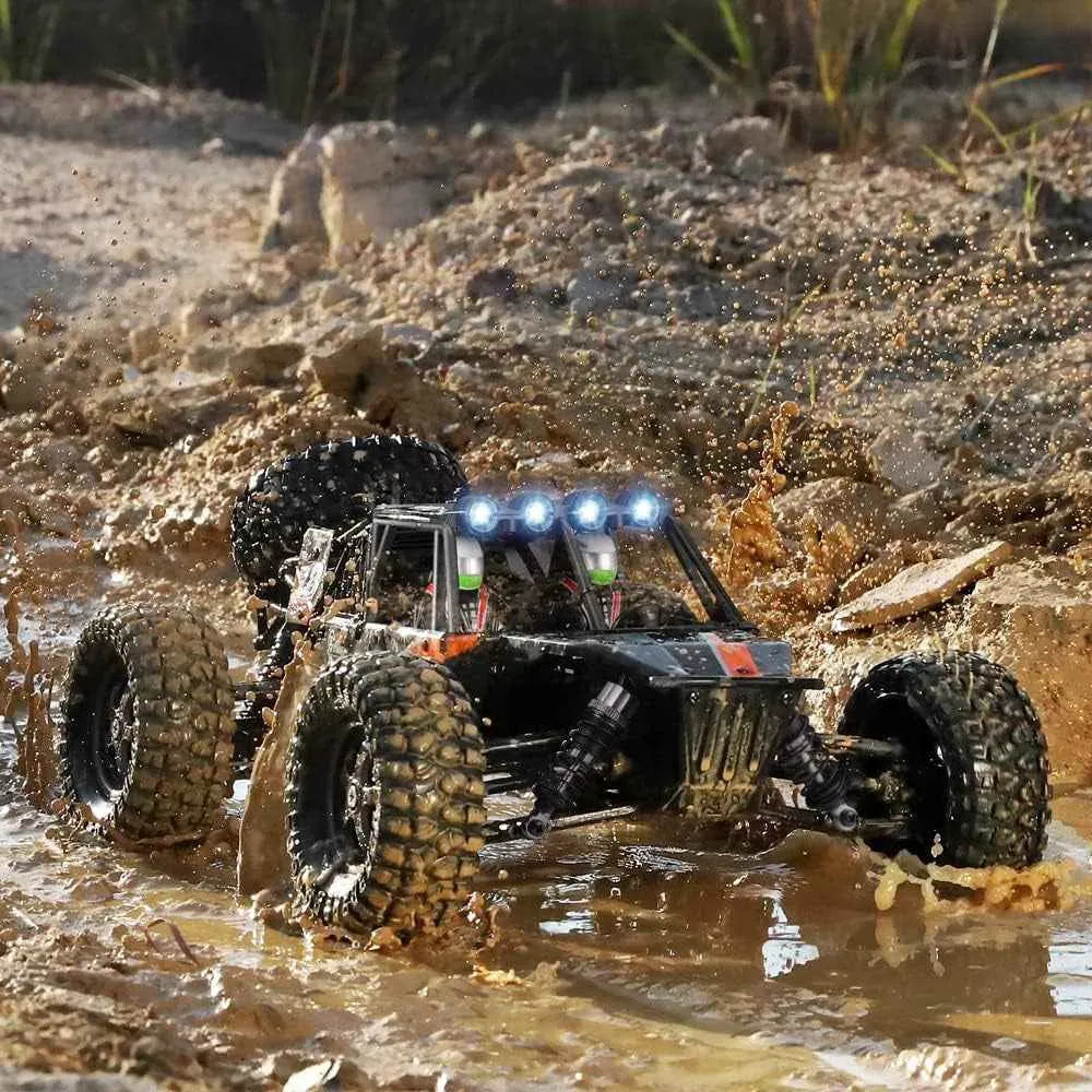 Off-road monster truck driving through a muddy terrain with rocks and water.