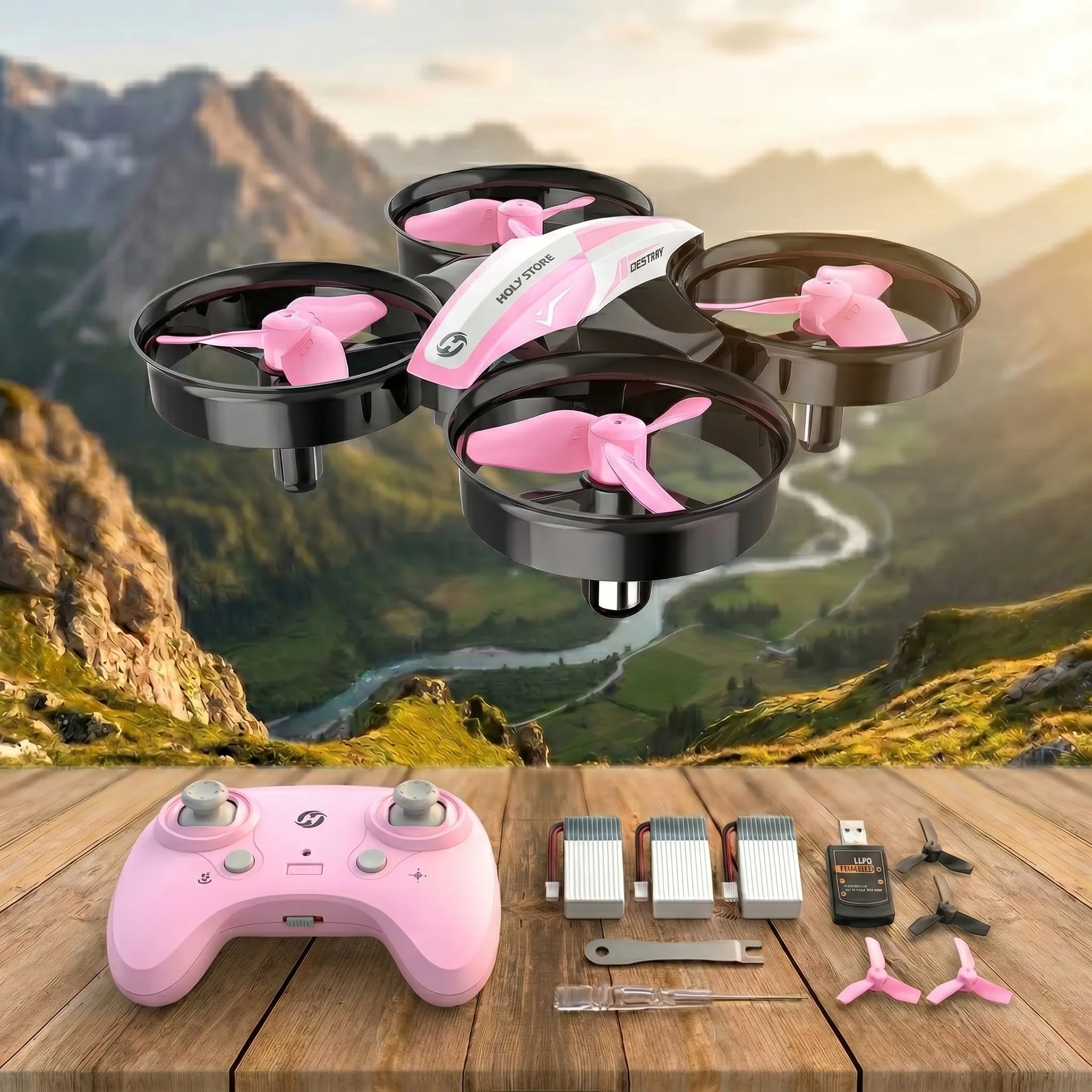 Pink RC drone with controller and accessories on a wooden surface with a mountainous background