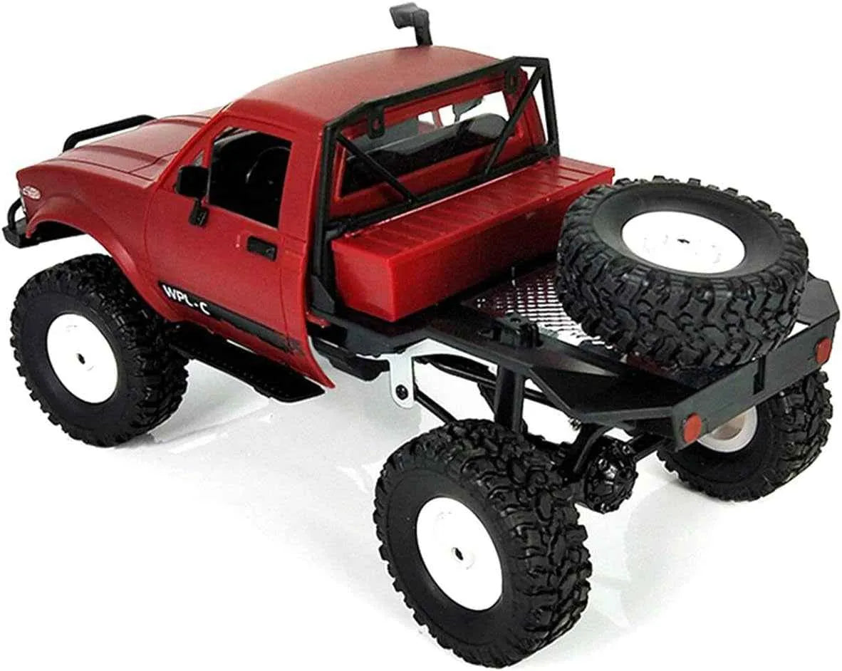 Red off-road rc crawler with large black tires on a white background