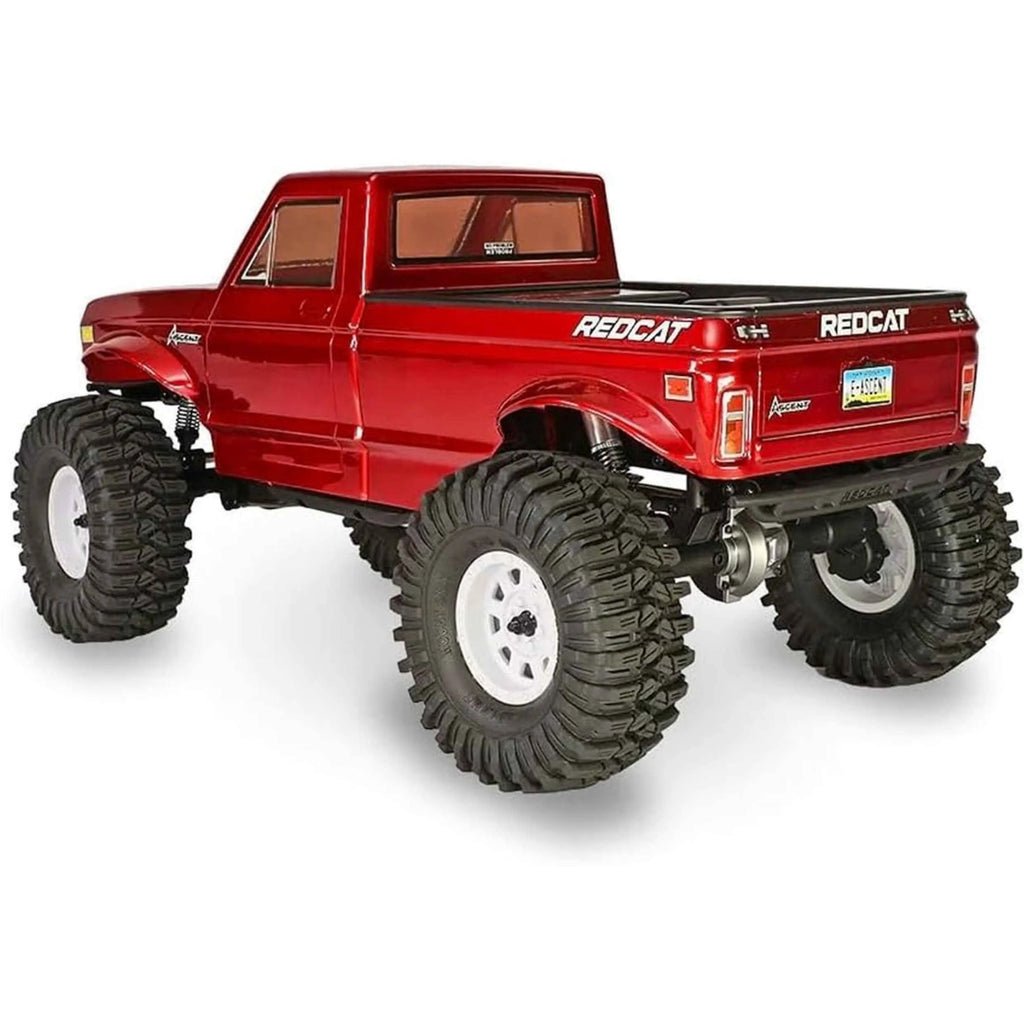 Red RC truck with large wheels on a white background