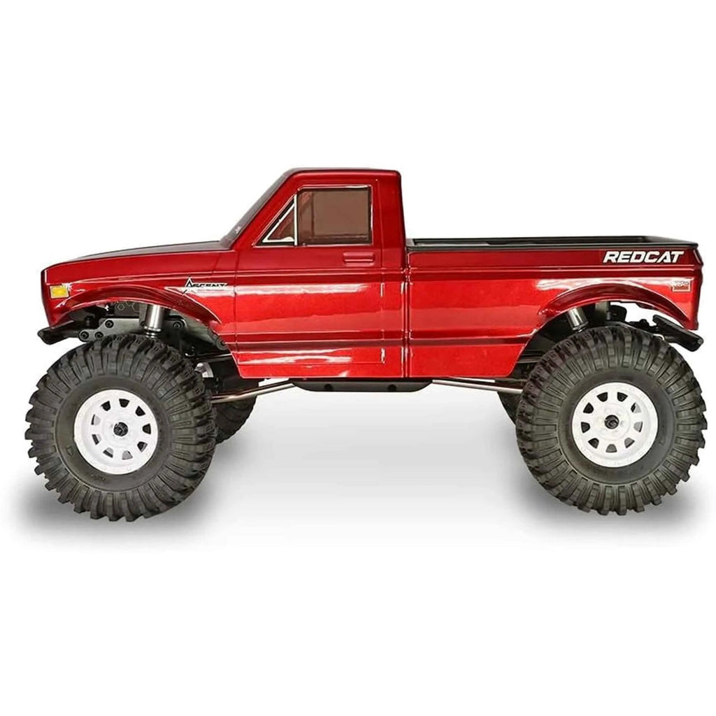 Red RC crawler side look with large wheels on a white background