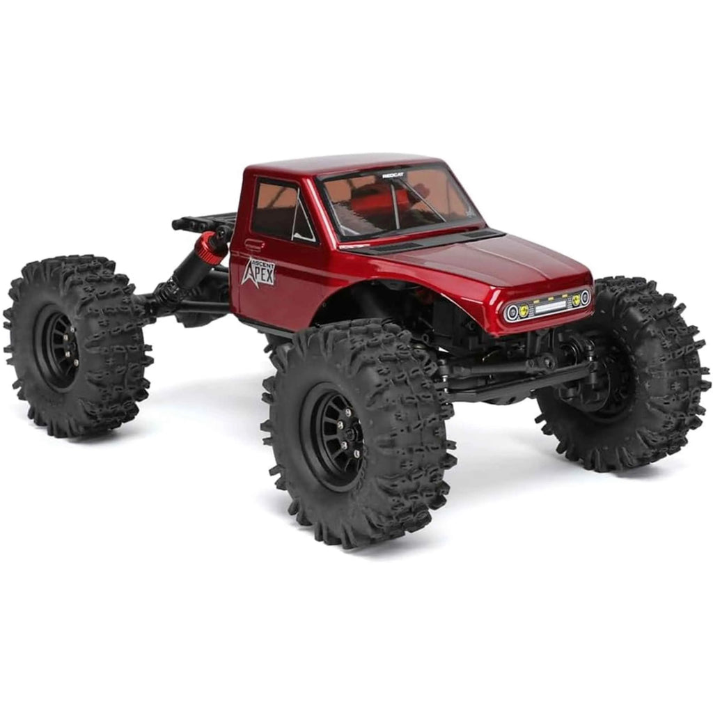 Red RC crawler with large black tires on a white background