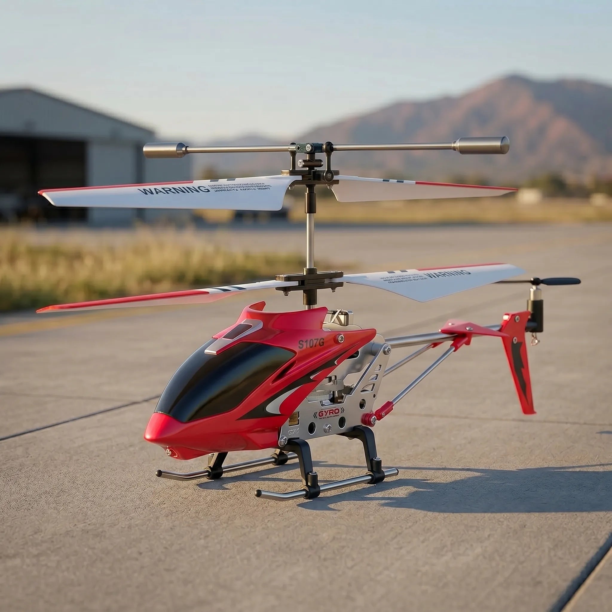 Red RC helicopter on a tarmac with mountains in the background