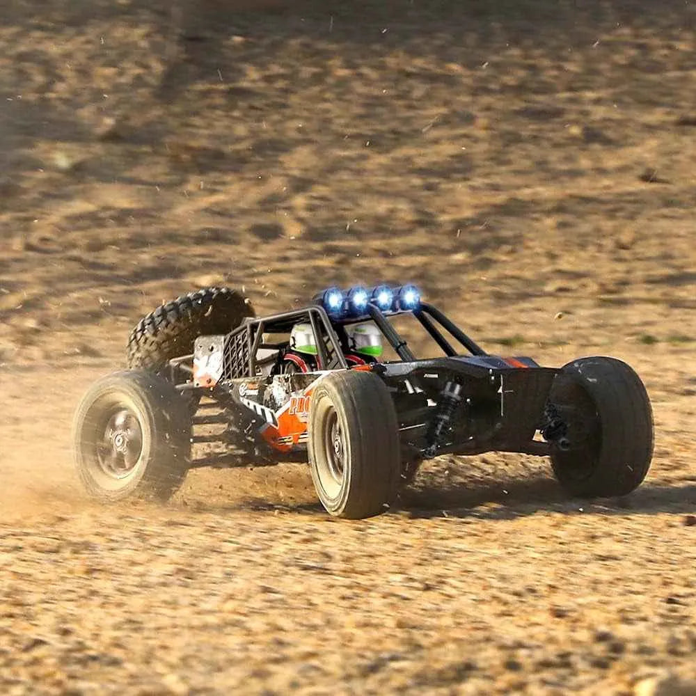 Remote-controlled off-road monster truck with lights on a dirt surface