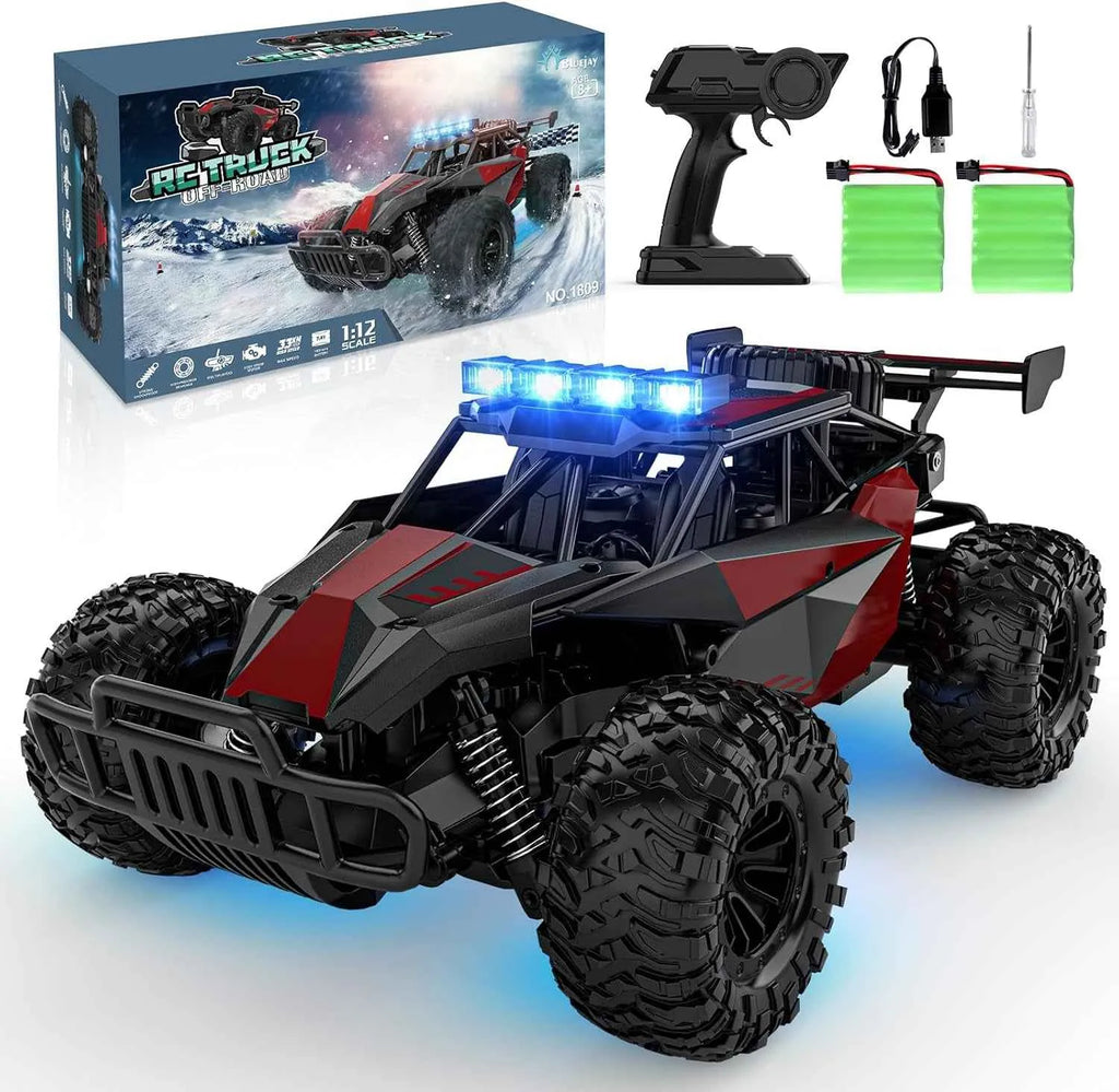 Remote control monster truck with lights, controller, and batteries on a white background