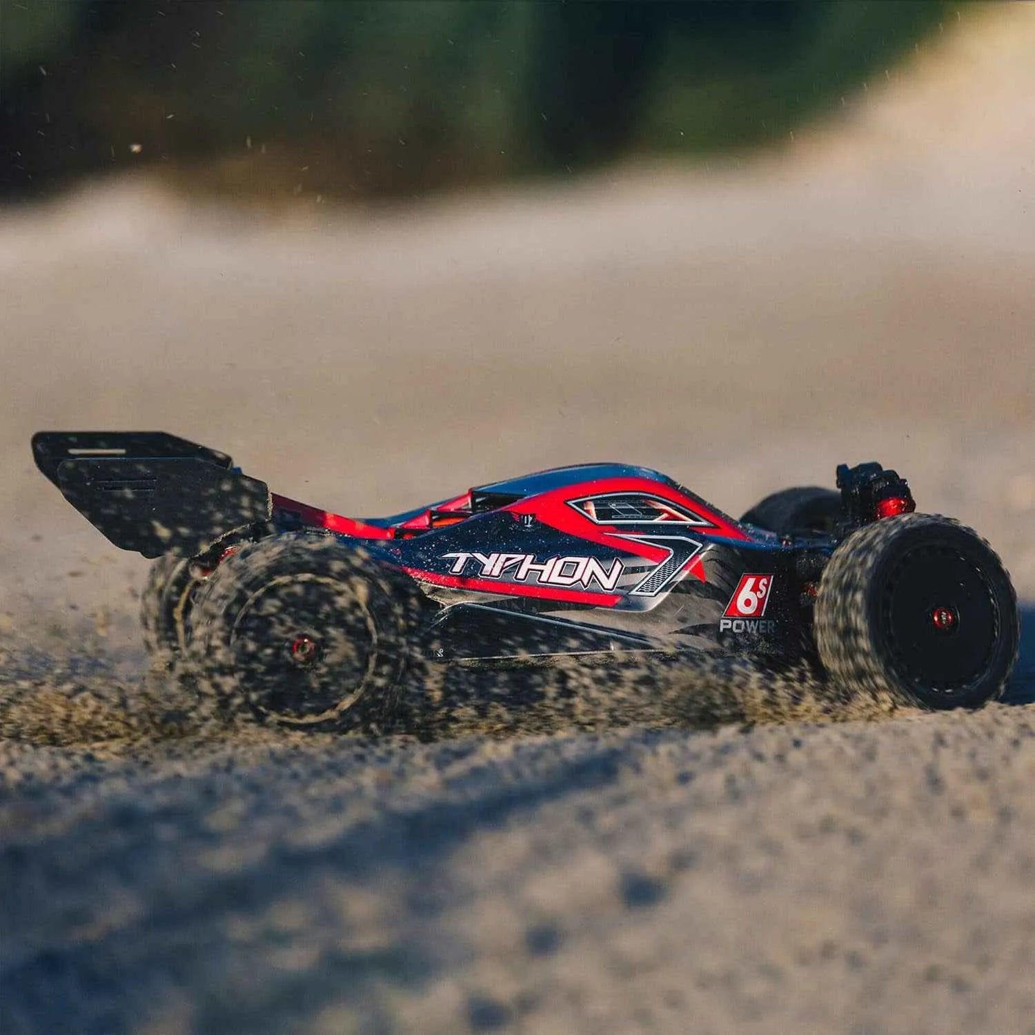 Remote control off-road buggy on a sandy surface with 'Typhon' branding.