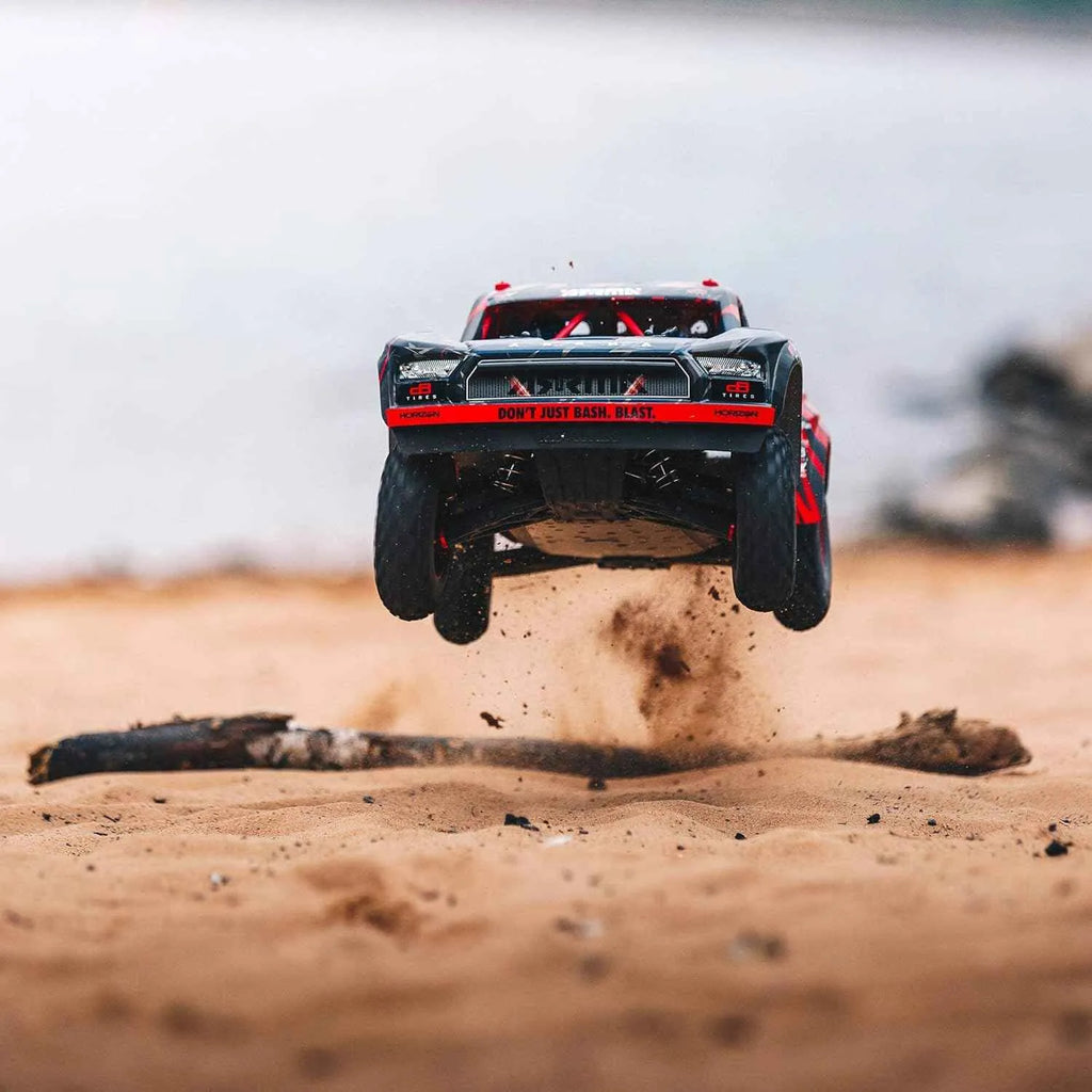Off-road vehicle in mid-air over a sandy surface
