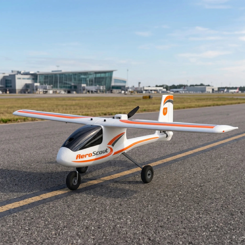 Small RC aircraft labeled 'AeroScout' on a runway with buildings in the background